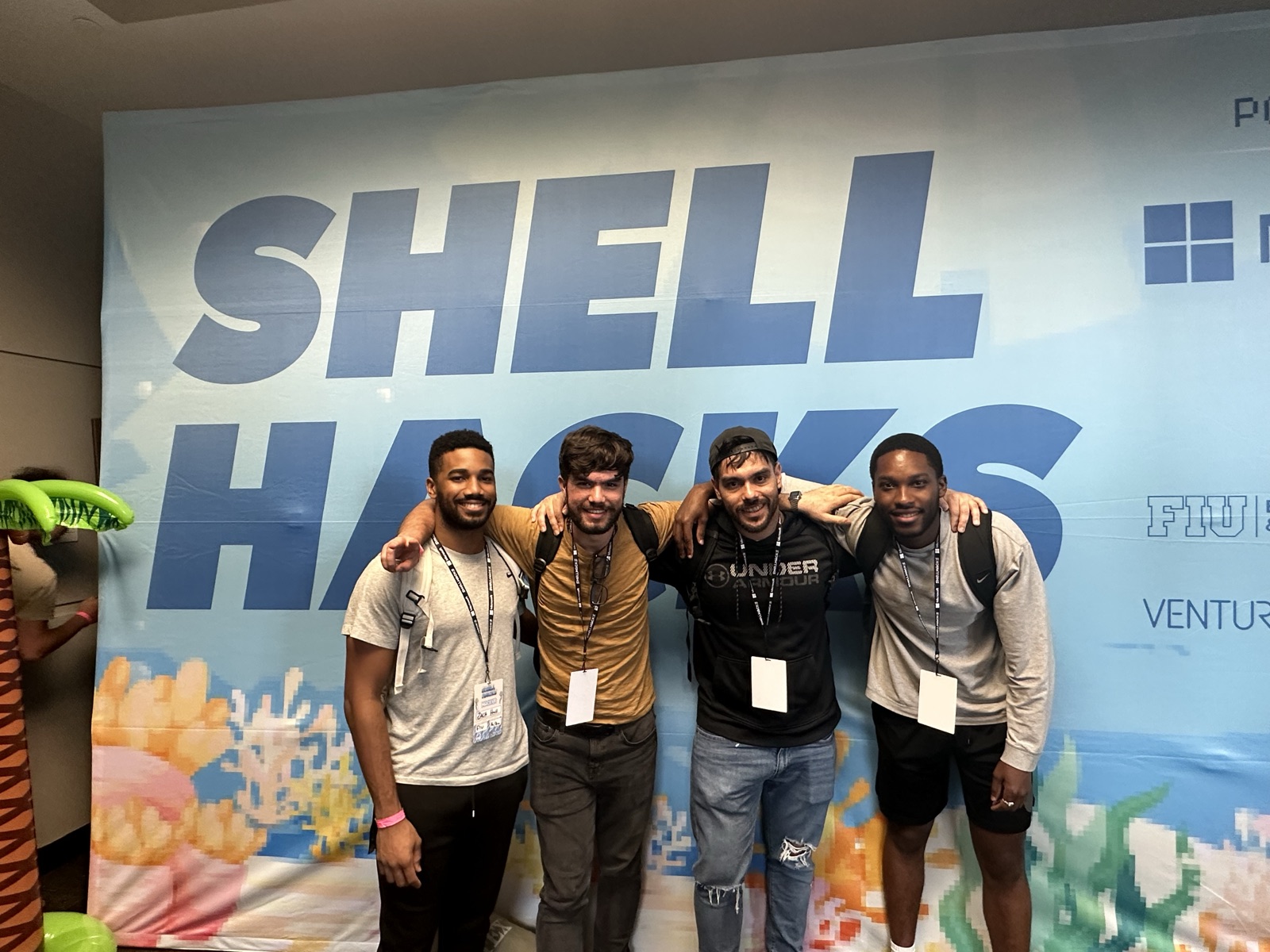 Four teammates arm in arm at the ShellHacks hackathon